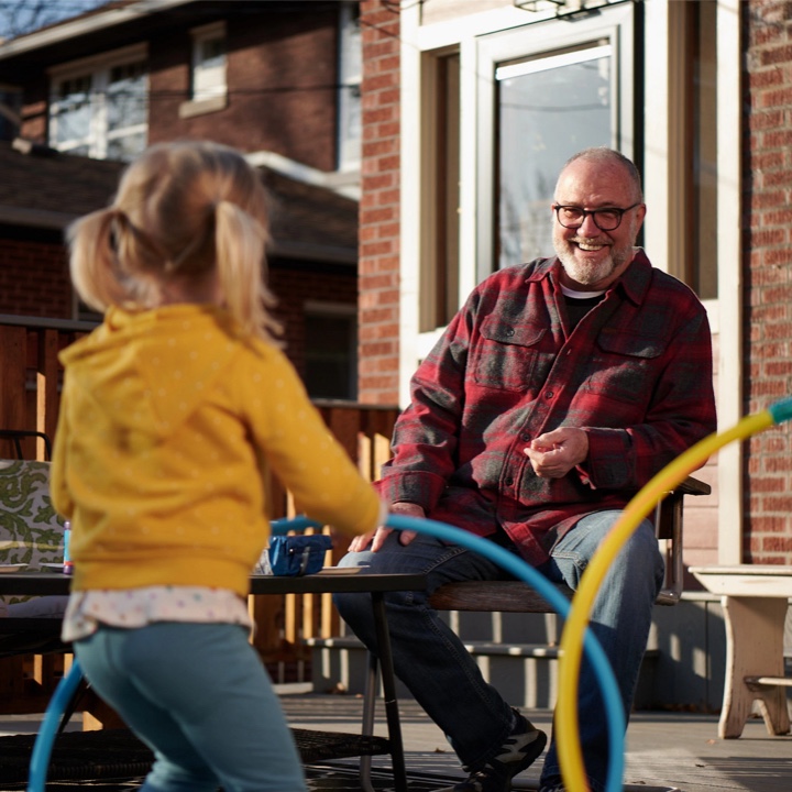Grandparent protected by a whole life policy with his grandchild playing outdoors
