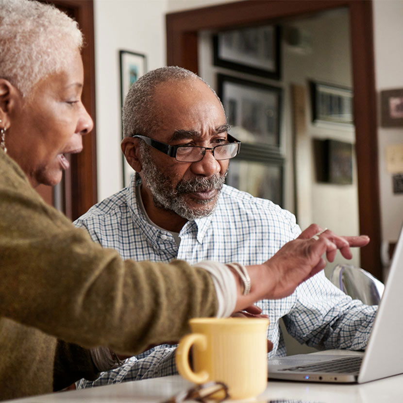 Two people looking at the peformance of their annuities on a laptop computer