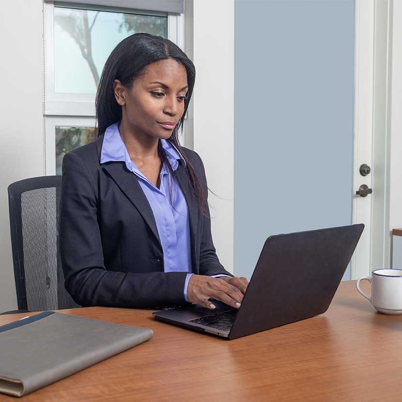 Financial professional reads about TruStage Elevate advanced planning resources on her laptop