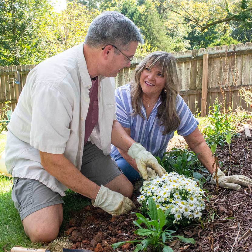 A retired couple plants flowers and feels secure about their financial future, thanks to a fixed annuity from TruStage™.