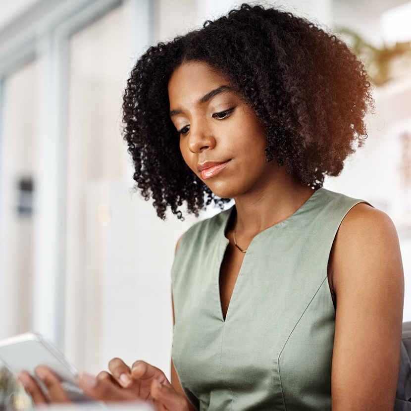 A woman uses her smartphone to check her retirement portfolio which includes a TruStage™ Registered Index-Linked Annuity (RILA).