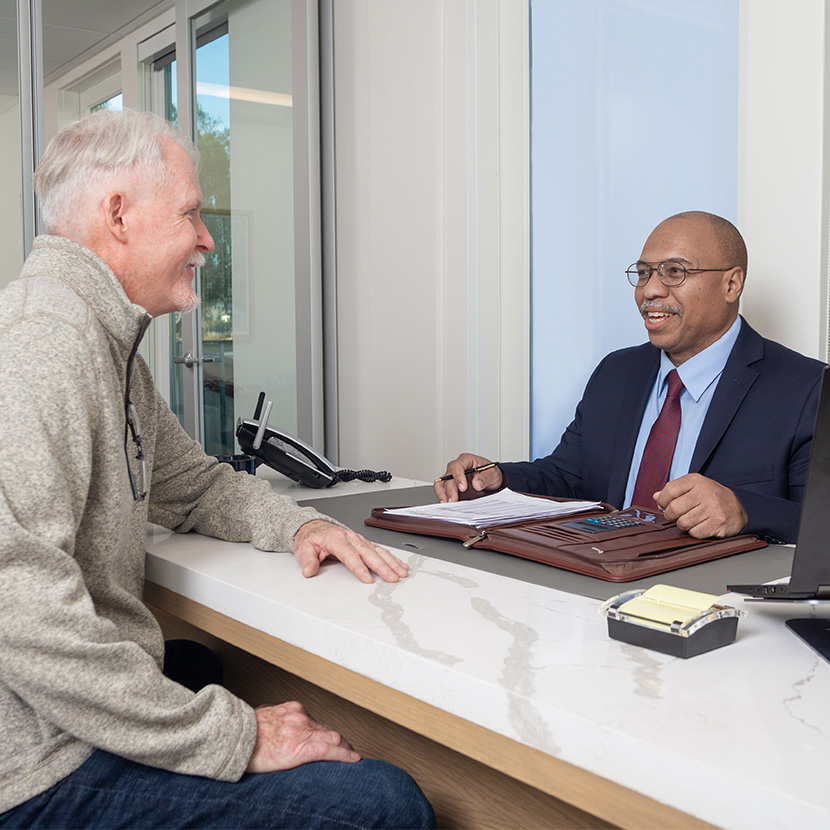 A retiree and his financial professional discuss performance of their TruStage™ Zone Income registered index-linked annuity.