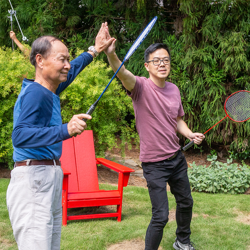 Two men playing badminton high fiving