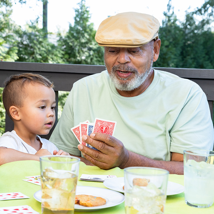 Grandfather and grandson playing cards with grandson use MEMBERS® Future Income Annuity's power of deferral to help maximize guaranteed future income.