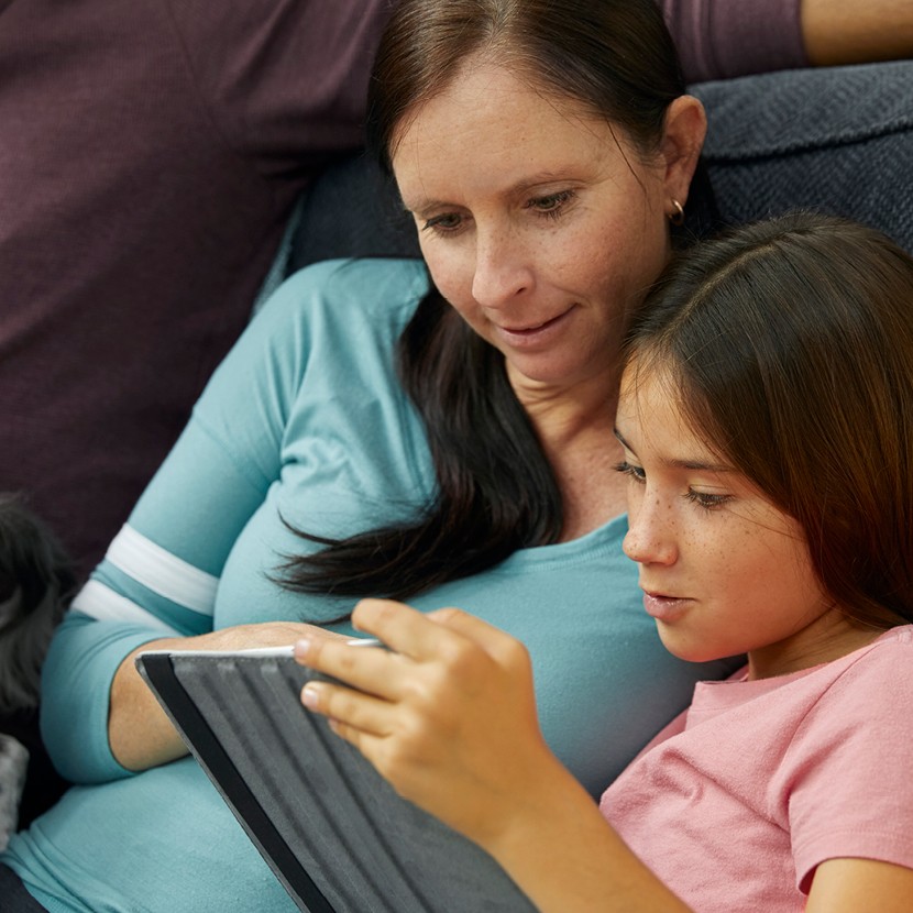 Mother and daughter looking at a tablet reviewing their insurance needs
