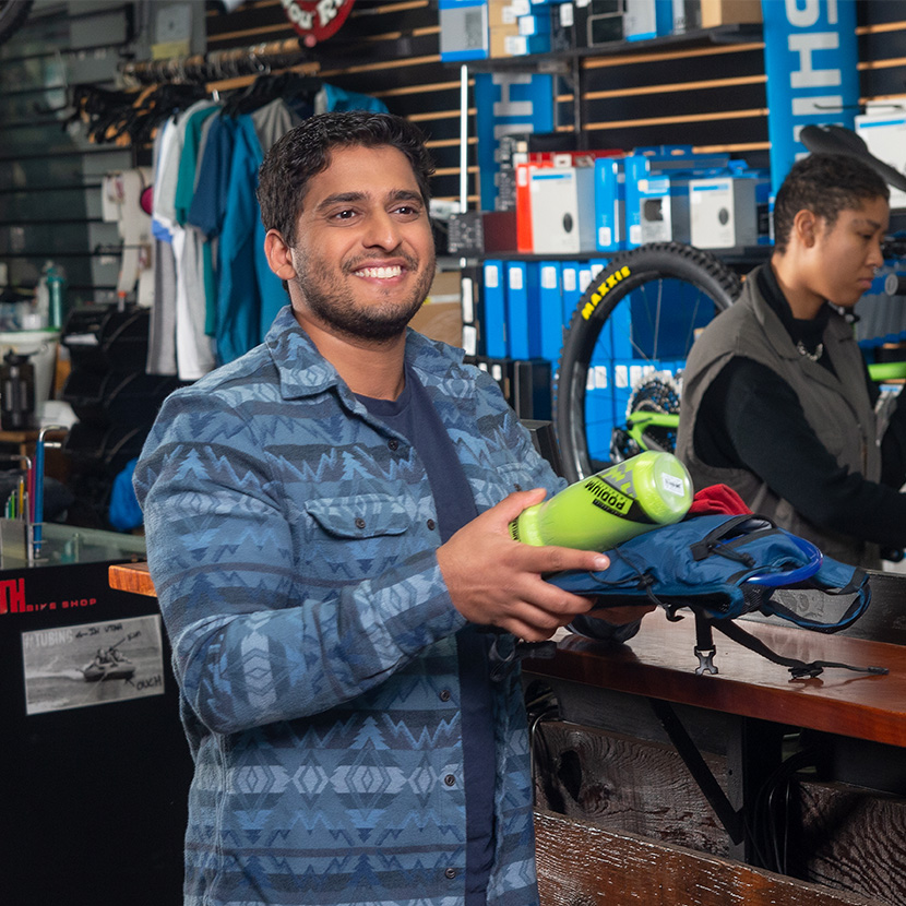 Man shopping for bicycle parts feeling secure about his retirement, thanks to TruStage™ Annuities.