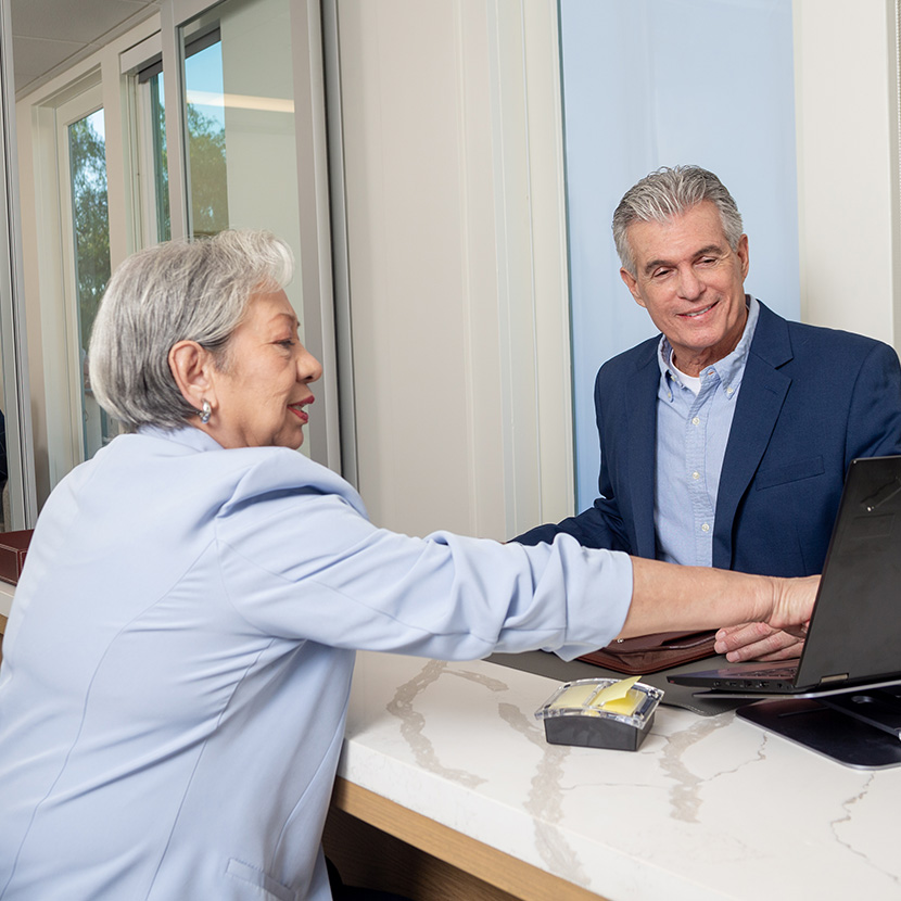 Woman pointing to screen while man observes